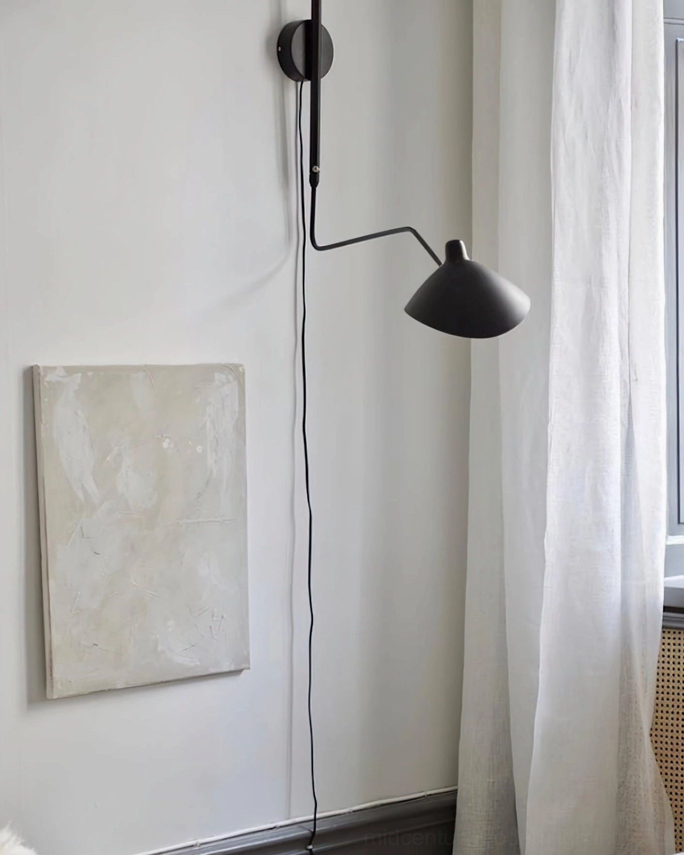 Single-arm plug-in spider sconce in matte black demonstrating independent shade rotation