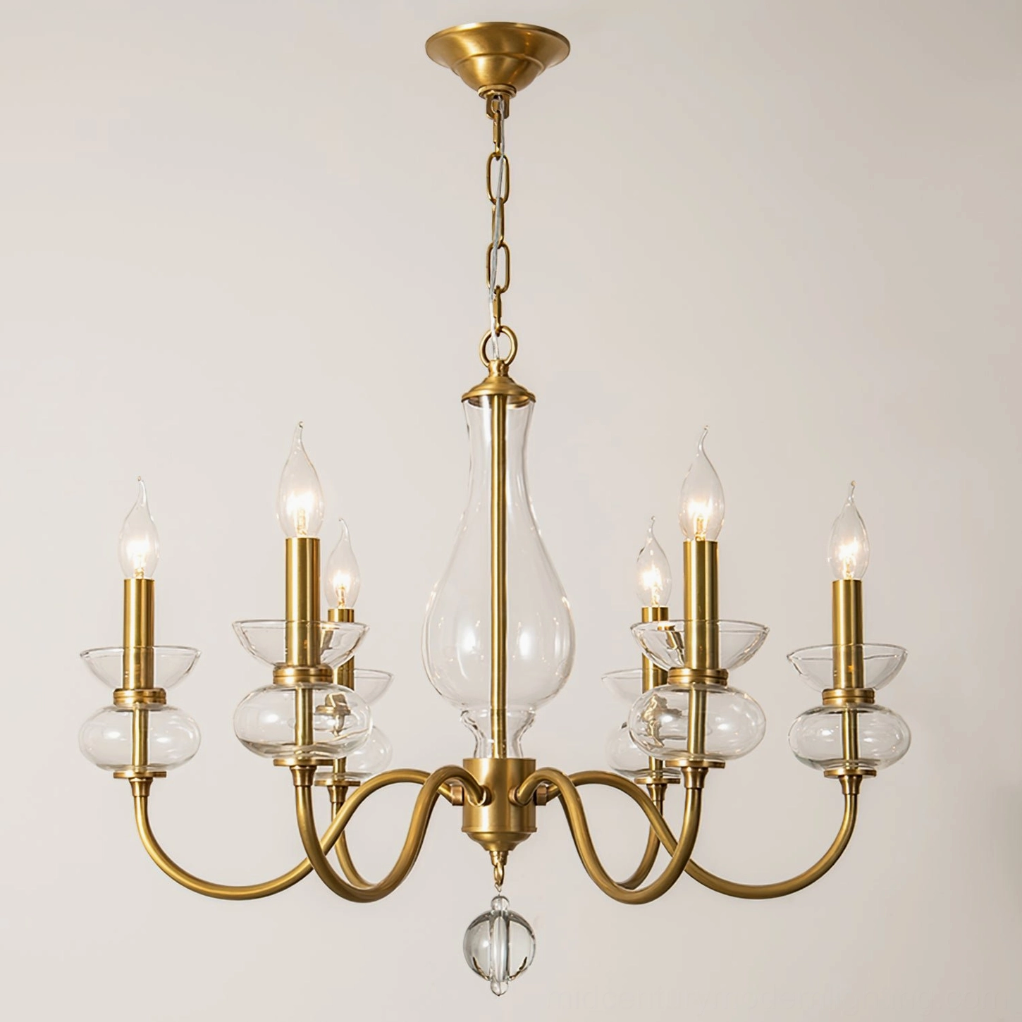 Mid-century modern brass chandelier curved arms clear glass accents front view minimalist
