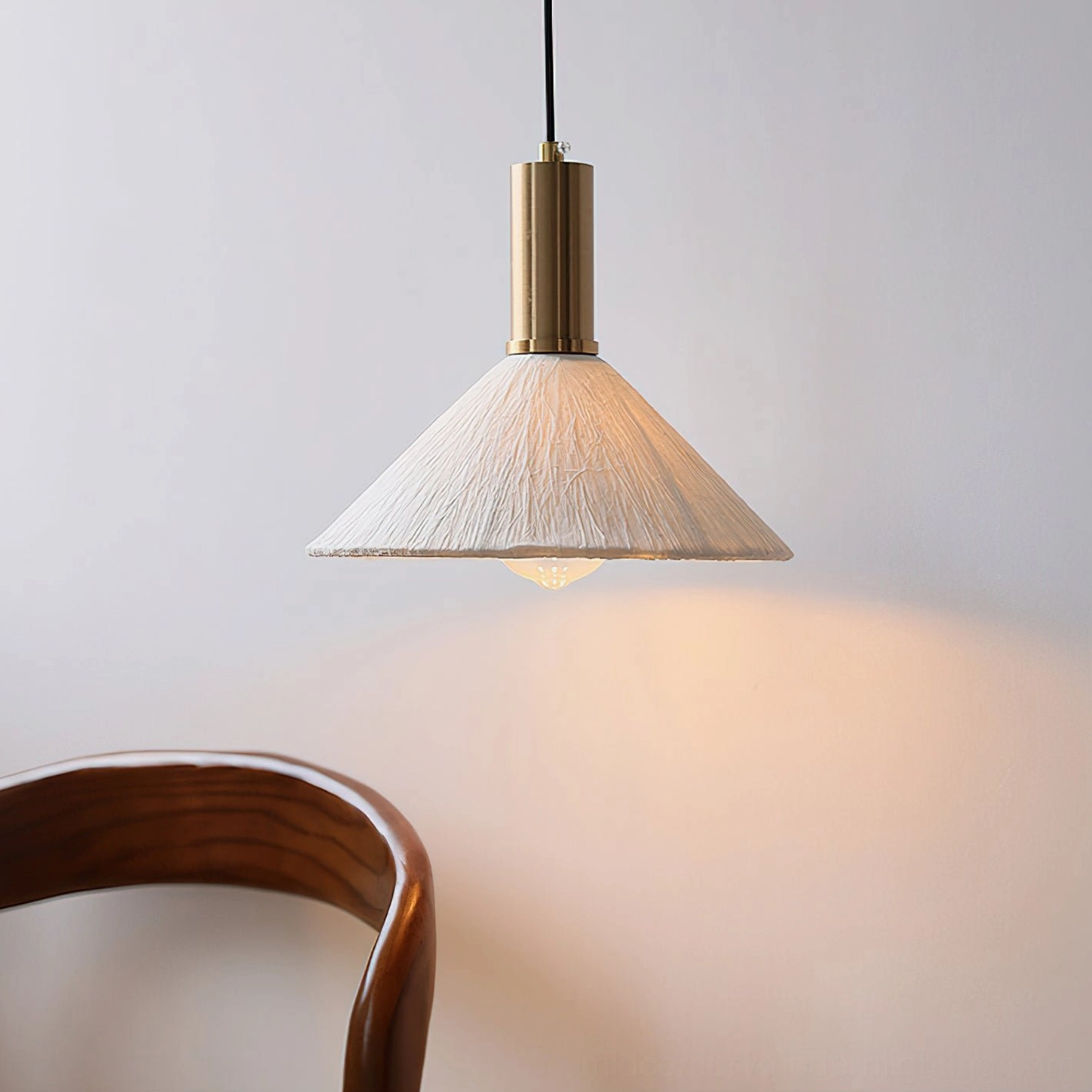 Siya cone pendant light minimalist boho design front view against blank wall with wooden dining chair