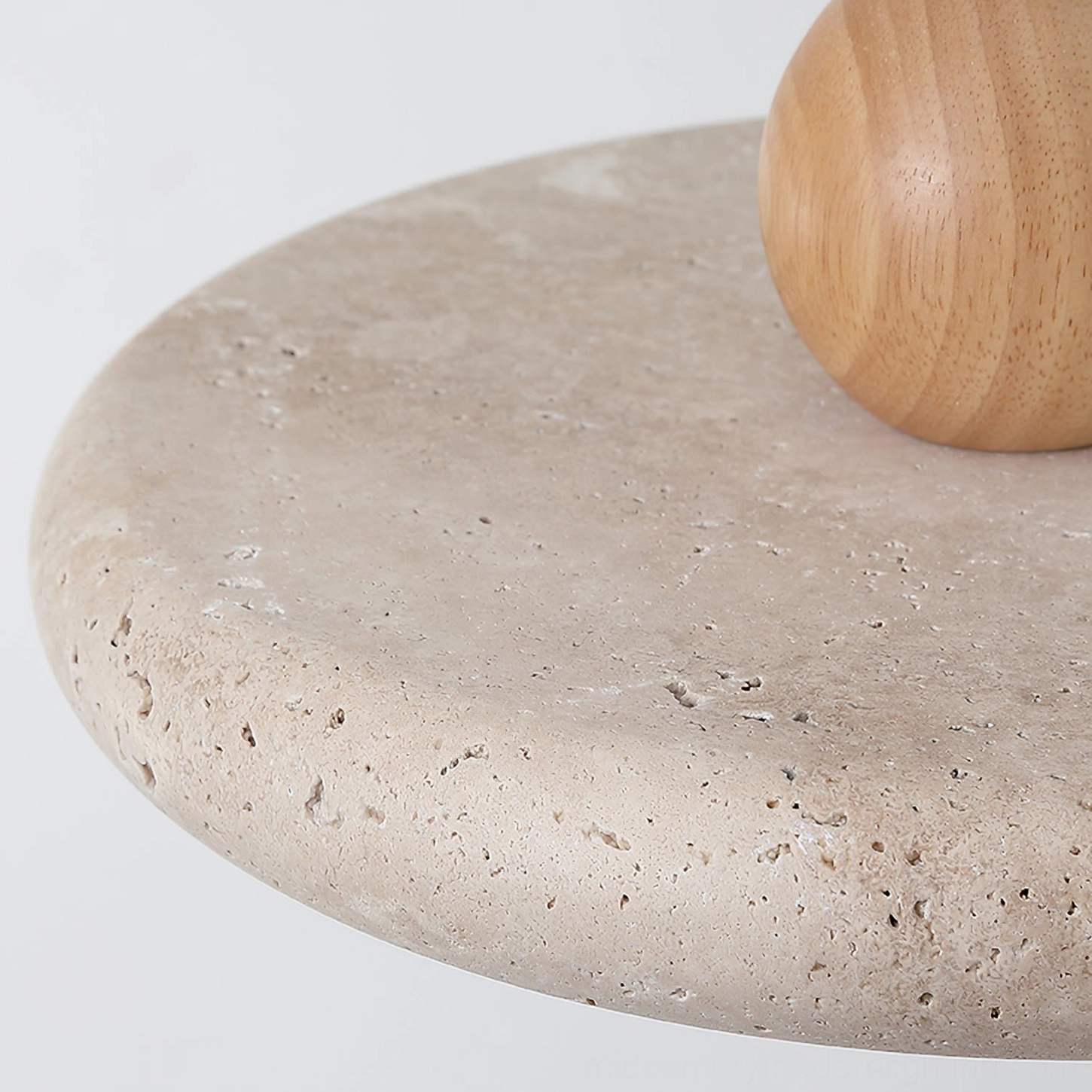 Siyane pendant lamp components: natural travertine disc shade and solid wood sphere on white studio background