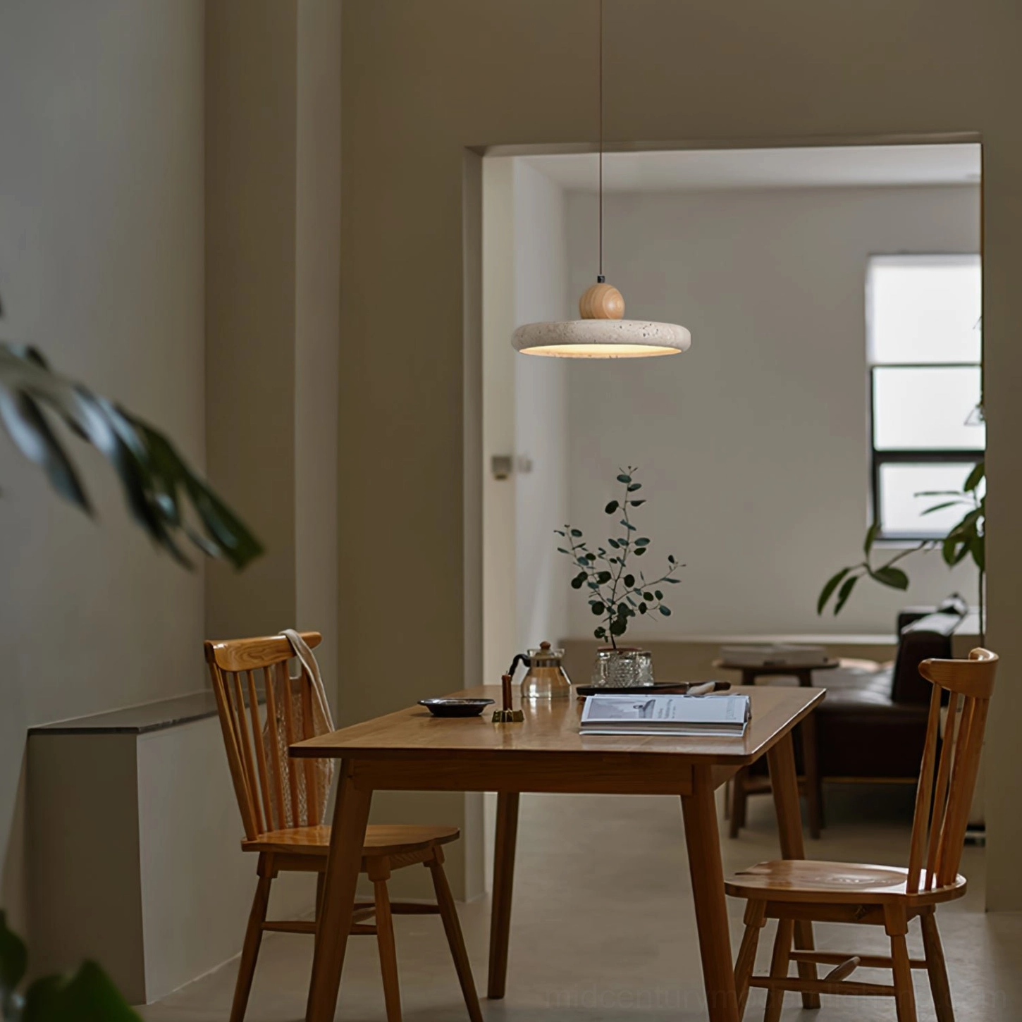 Siyane travertine pendant light installed in warm minimalist Japanese dining room with wooden table