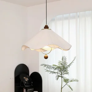 Sloane pendant lamp three-quarter side view in French-inspired living room with brown spherical bottom ornament detail and warm ambient lighting