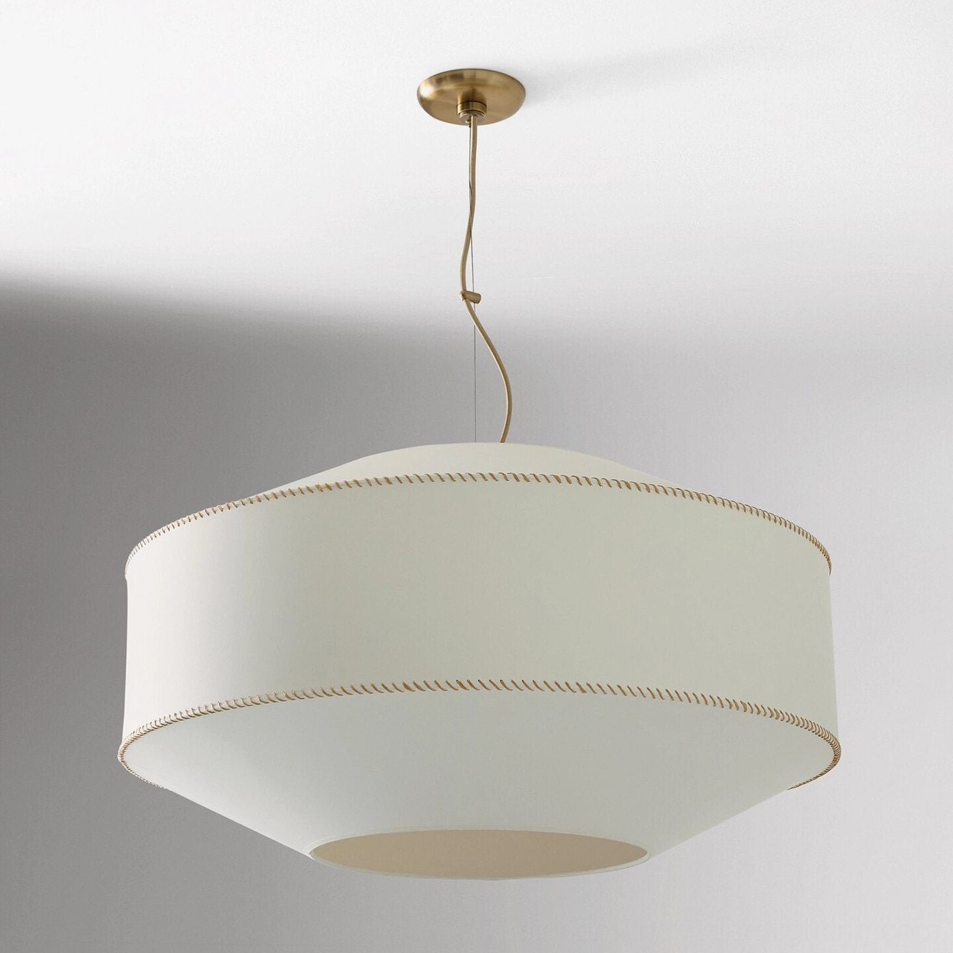 Sloane whipstitch pendant light suspended in modern interior showing linen fabric diffusion and brass details