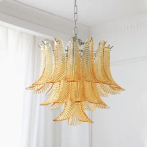 Small Amber Eclissi Tiered Glass Chandelier installed in bedroom with sheer curtains, showing chrome hanging chain and diagonal light refraction