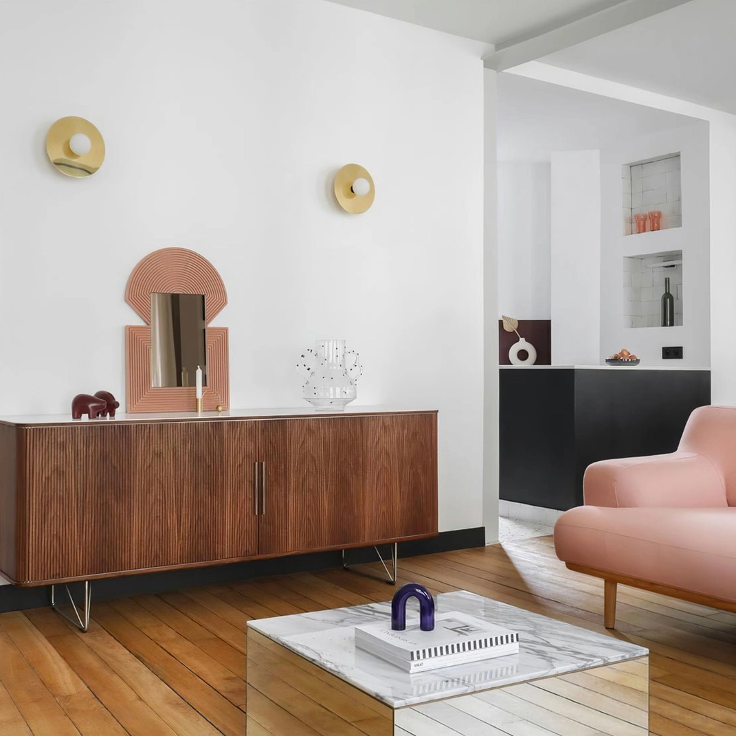 Compact brass disc wall sconces creating ambient lighting in minimalist living room