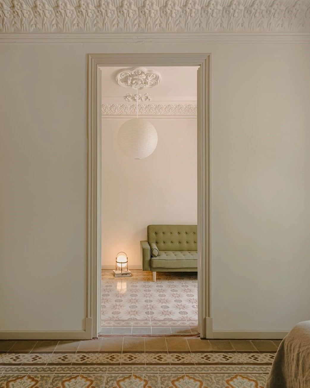 Small white washi paper sphere pendant lamp in classic vintage European residential corridor, warm neutral hallway lighting
