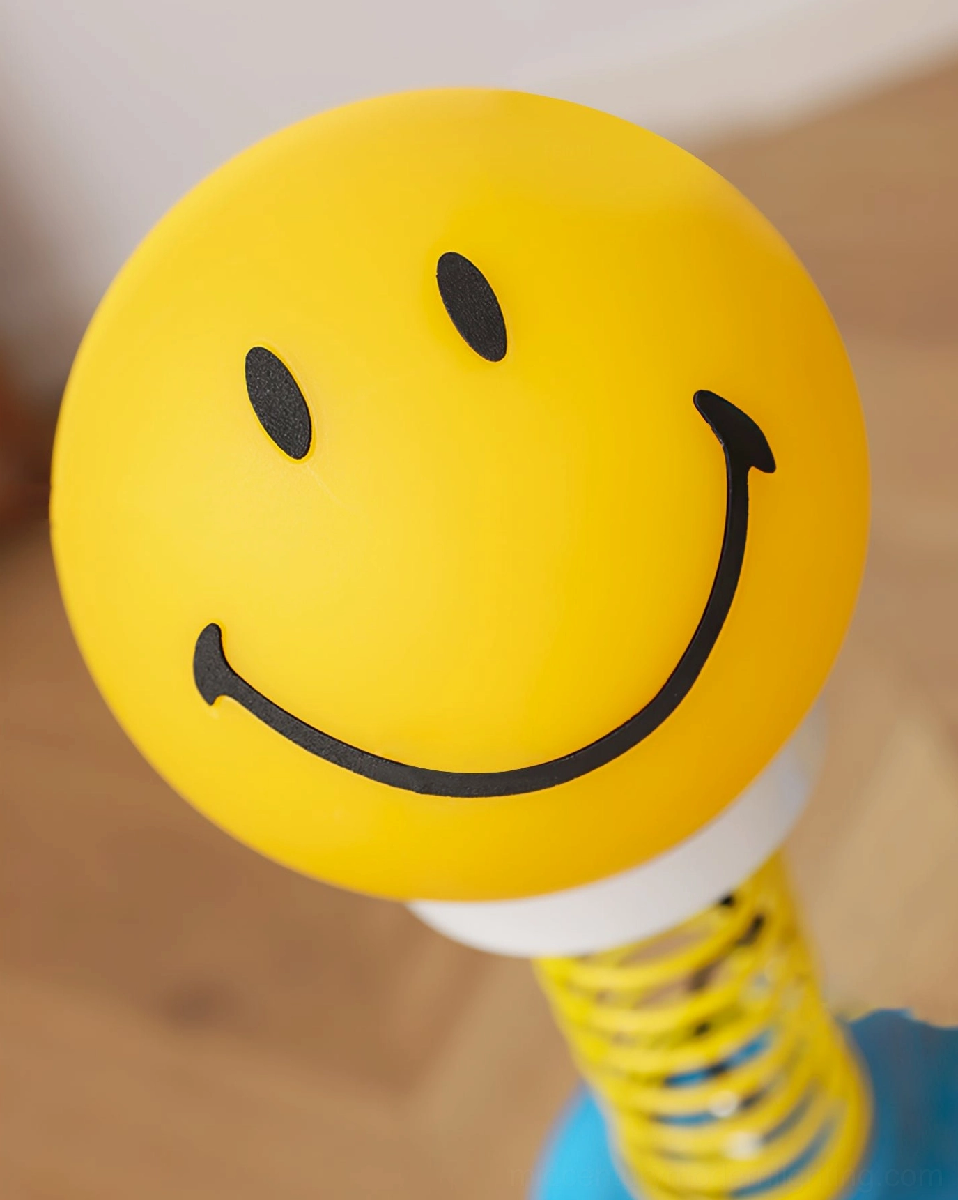 Close-up detail of black smiley face print on matte yellow lampshade, artistic print design