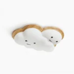 Smiling cloud ceiling lamp front view with cute face design, white acrylic shade with natural wood trim on studio background