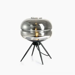 Smoke grey refraction glass table lamp with black metal base on white studio background, mid-century modern minimalist design