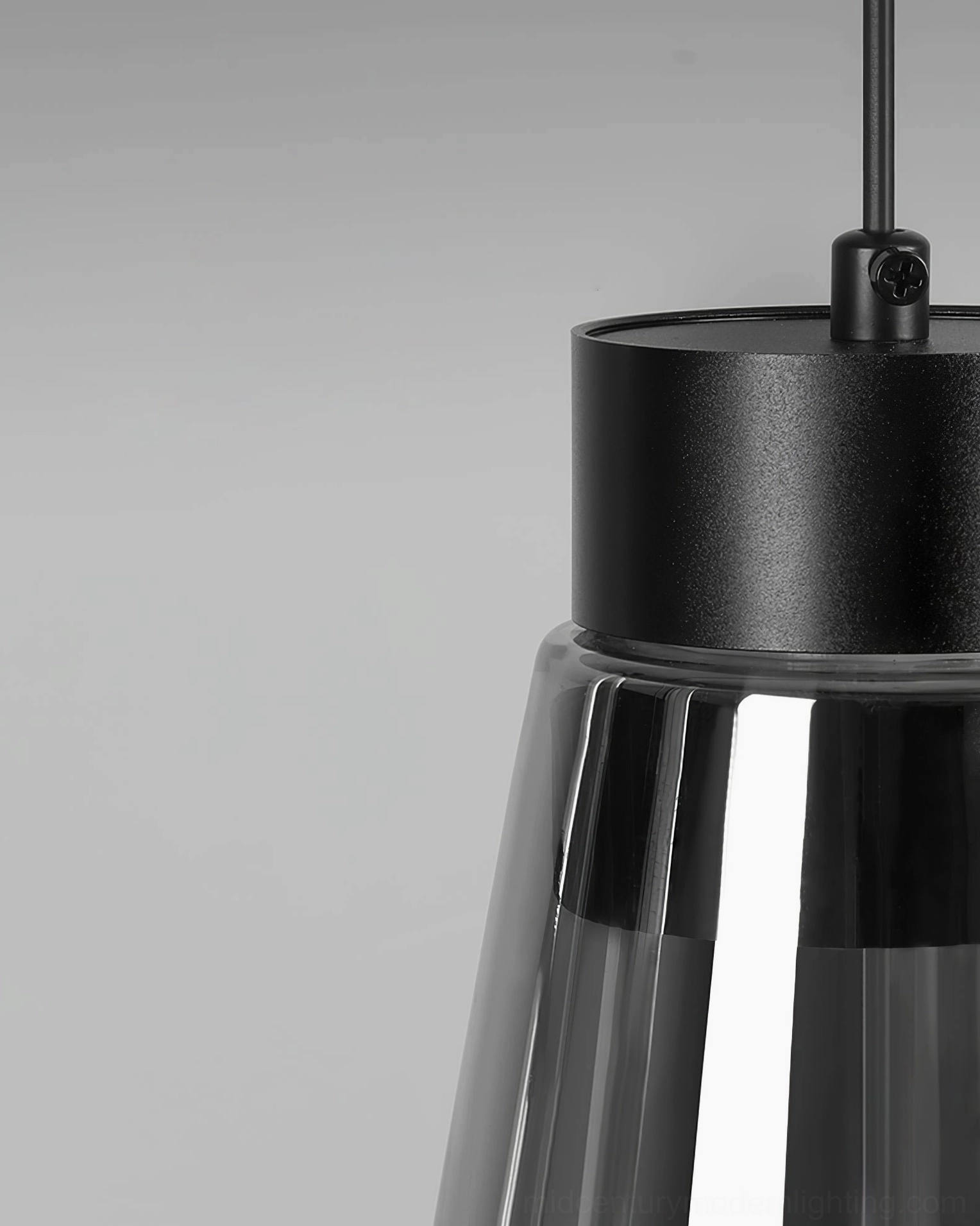 Modern cone pendant with smoked borosilicate glass shade over kitchen or dining space