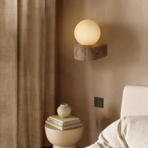 Lit solace wall light in bedroom corner creating warm ambient glow with natural stone base
