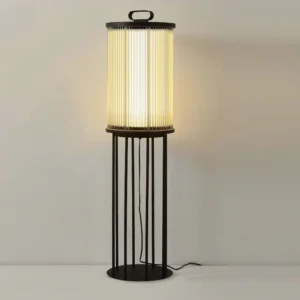 Lit solar floor lantern emitting warm ambient yellow light through frosted glass shade, modern outdoor lighting