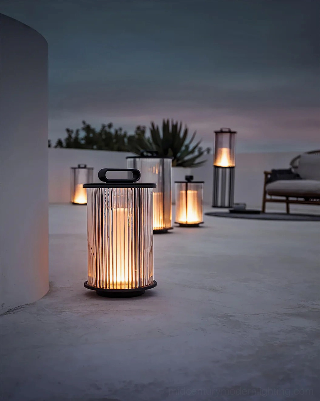 Multiple solar lantern collection arranged on rooftop patio at dusk