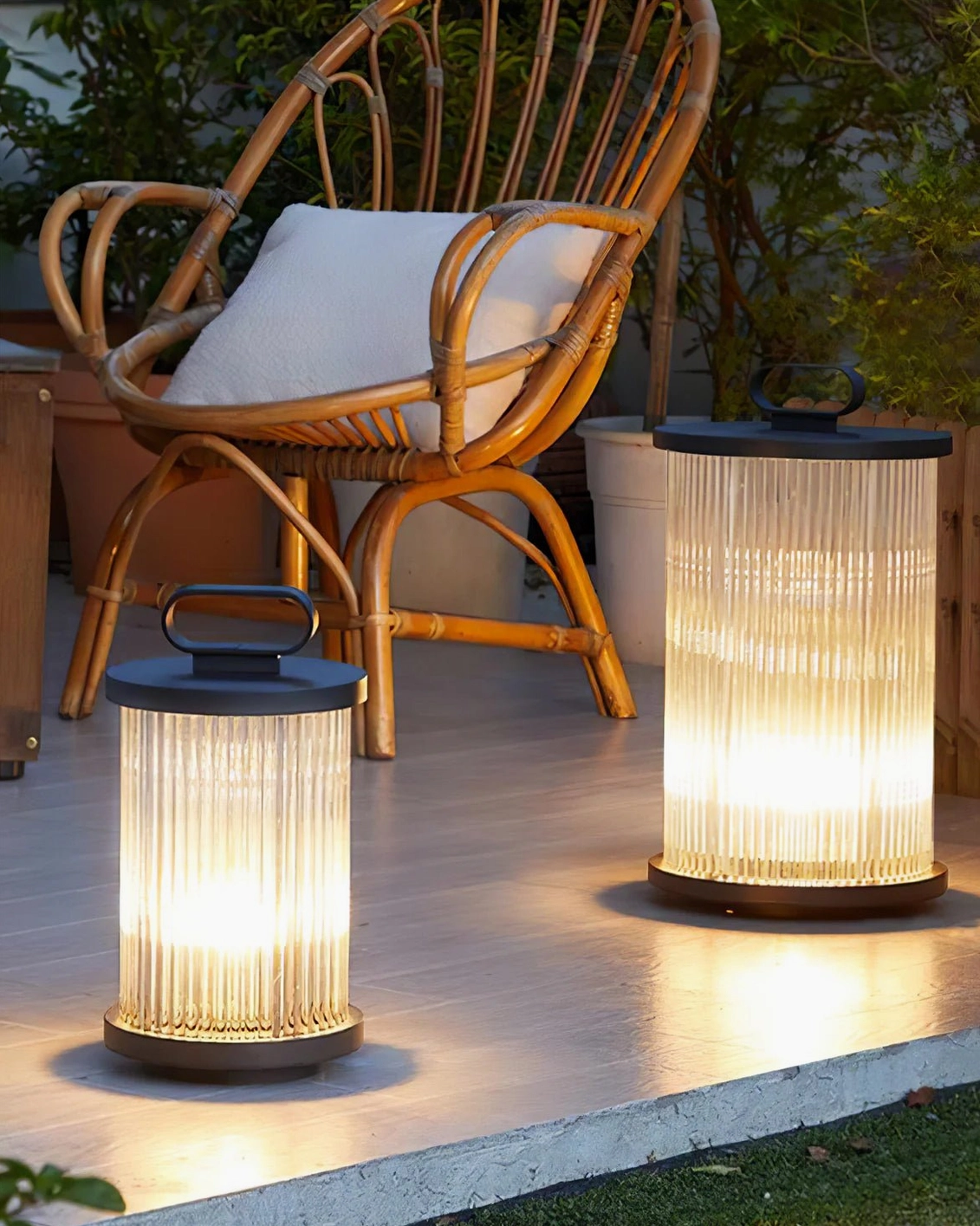 Two sizes of solar glass lanterns displayed on wooden patio terrace seating area