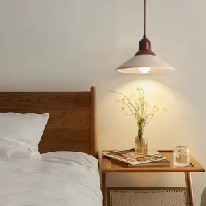 Solara pendant light hanging in minimalist bedroom above wooden nightstand with warm ambient lighting