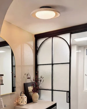 Solis Travertine Ceiling Mount installed in modern luxury bathroom overhead ceiling view warm minimalist interior design