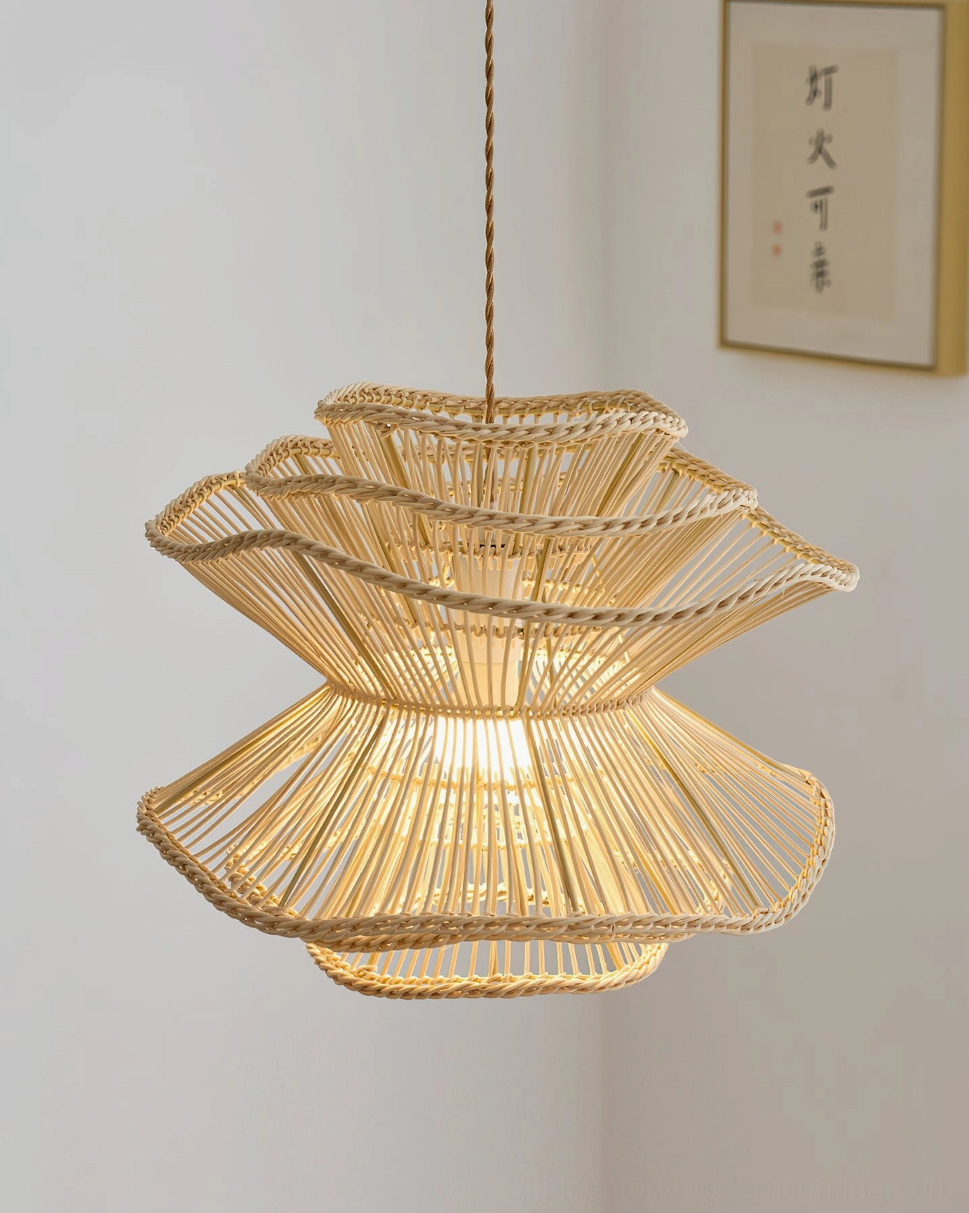 Illuminated Sombra rattan pendant light creating warm shadow patterns with artistic wall decor, twisted rattan edging detail