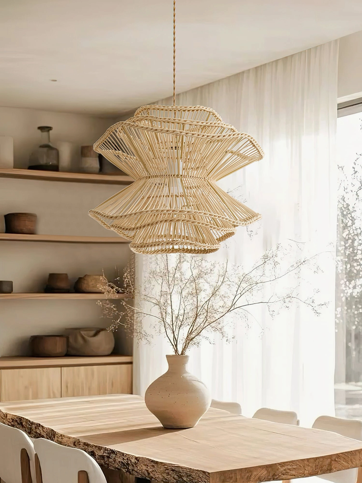 Sombra rattan pendant light in modern rustic dining space with wooden table, open shelving, and natural window light aesthetic