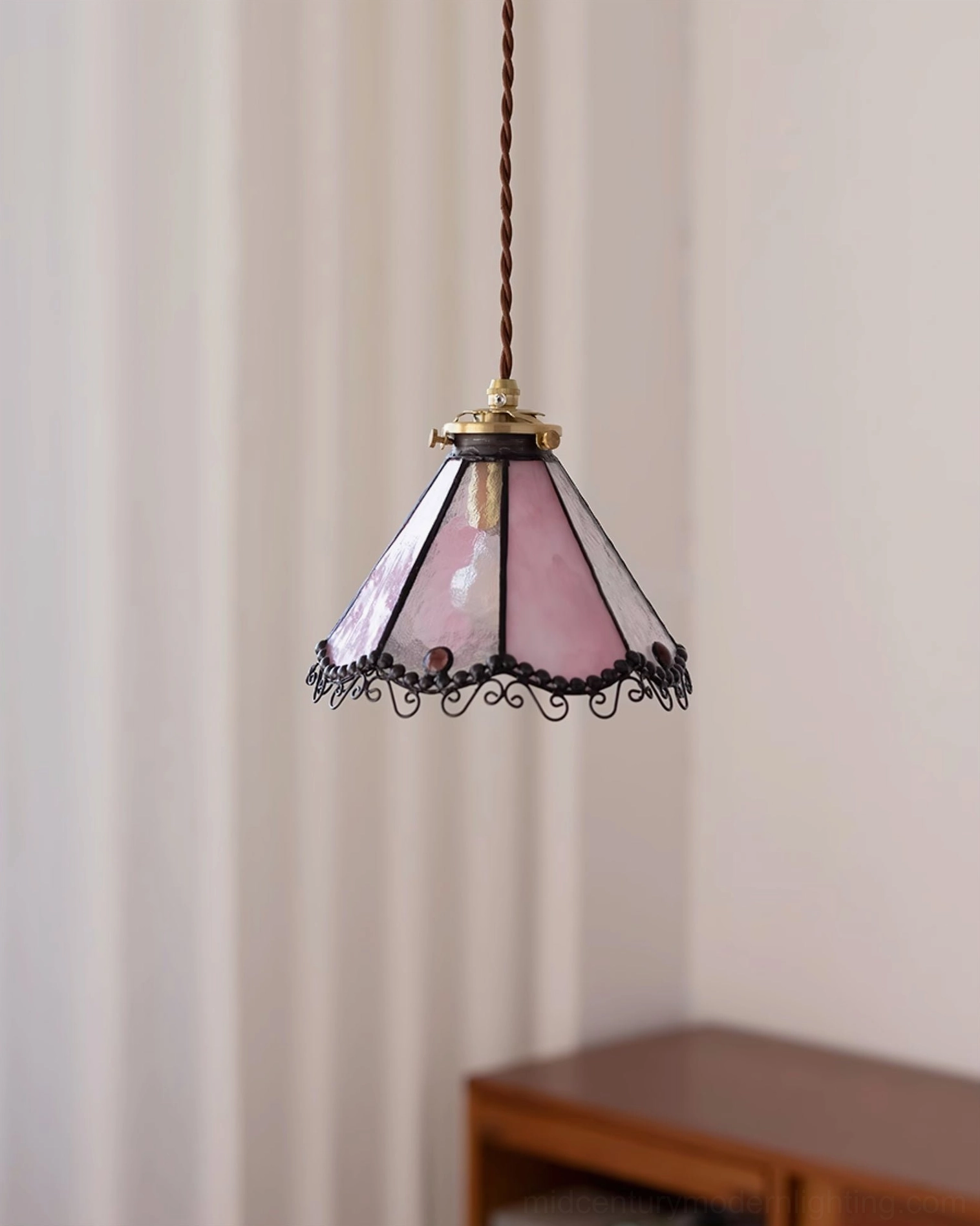 Sonoma Tiffany pendant lamp in pink and white stained glass displayed in modern dining room with wooden table and sheer curtains