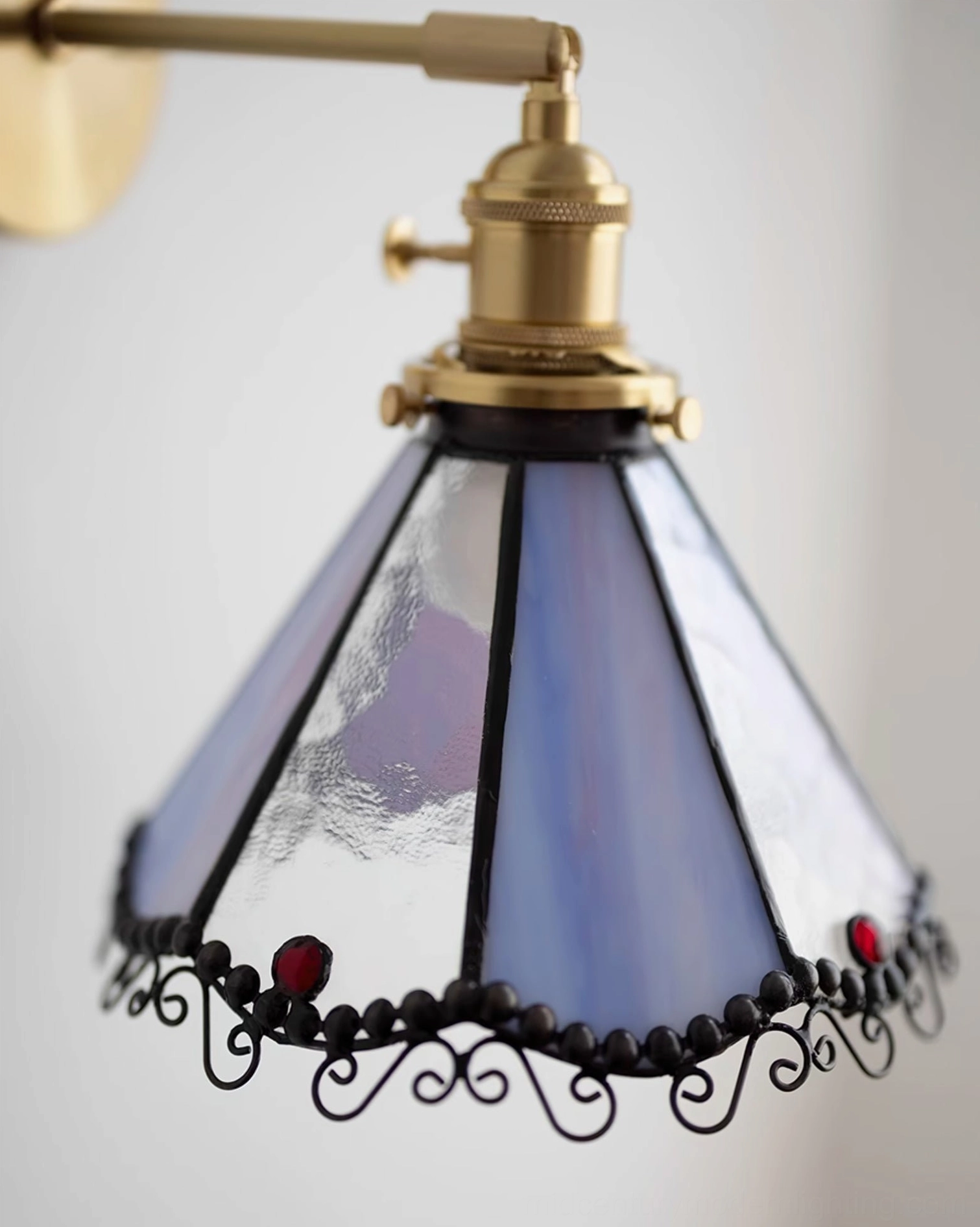 Detailed close-up of Sonoma Tiffany stained glass sconce showing textured blue-purple glass panels and red decorative beads