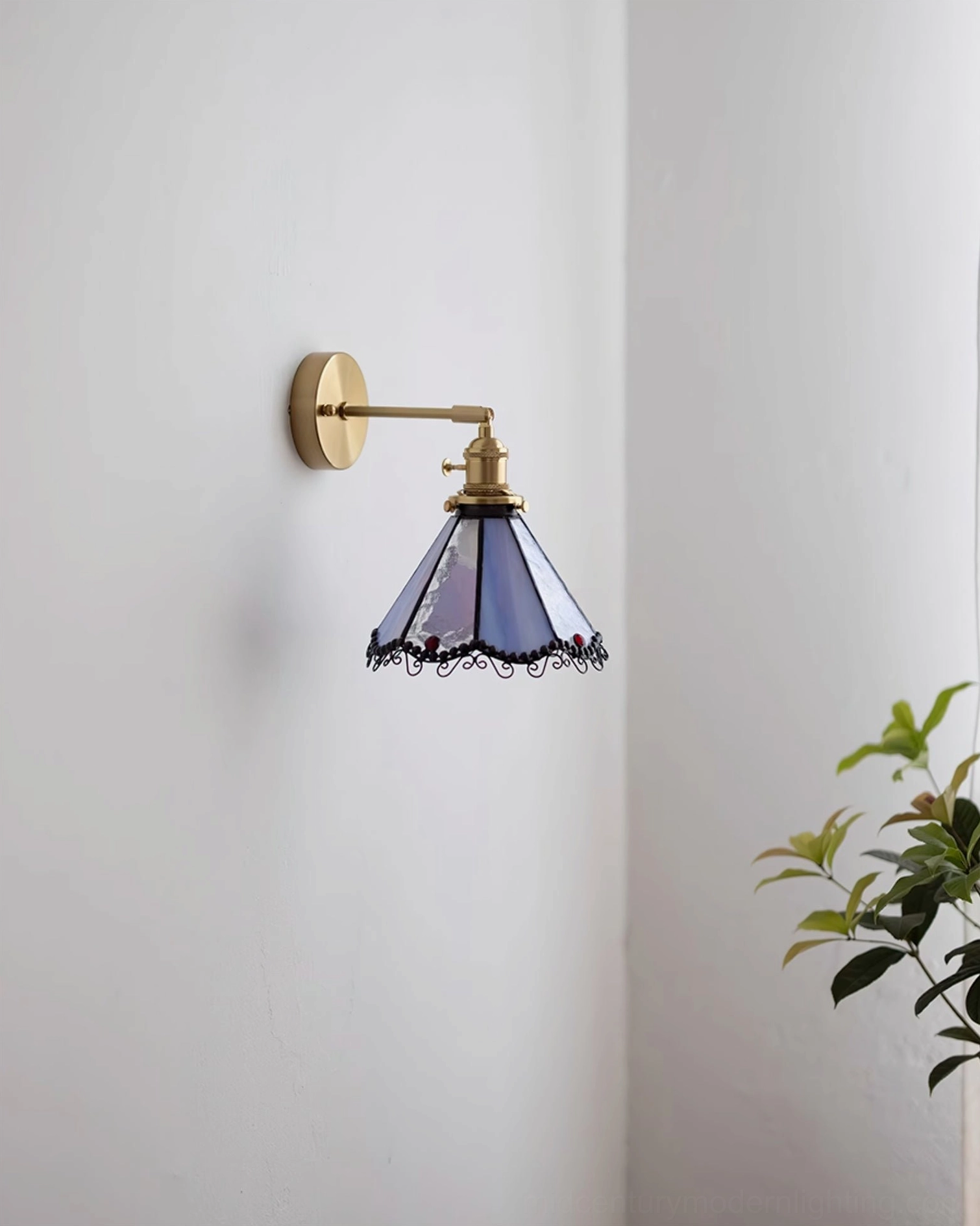 Side view of Sonoma Tiffany stained glass wall sconce in purple with ornamental black scrollwork trim and brass wall mount