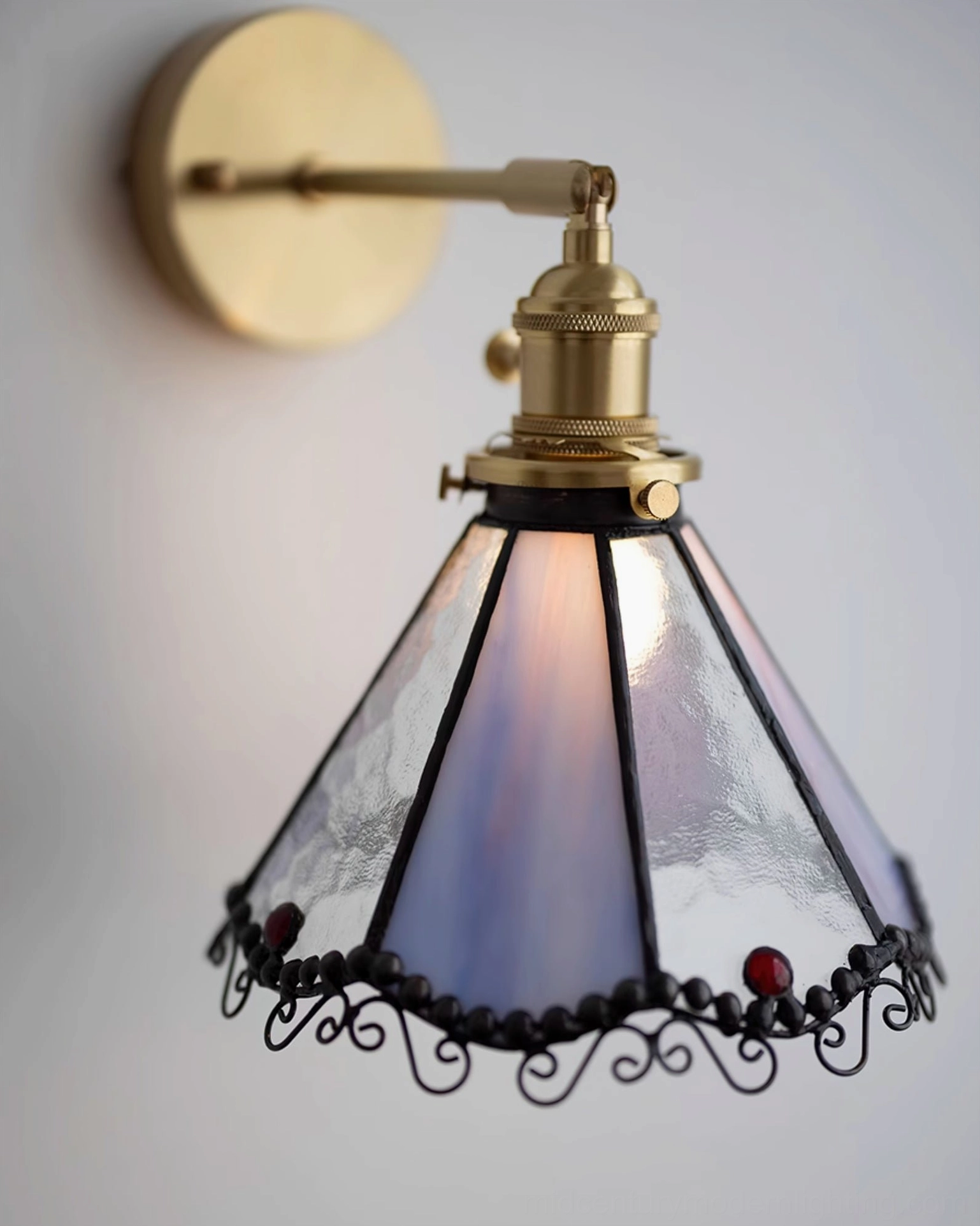 Sonoma Tiffany wall sconce showing brass hardware assembly and stained glass attachment mechanism from side angle