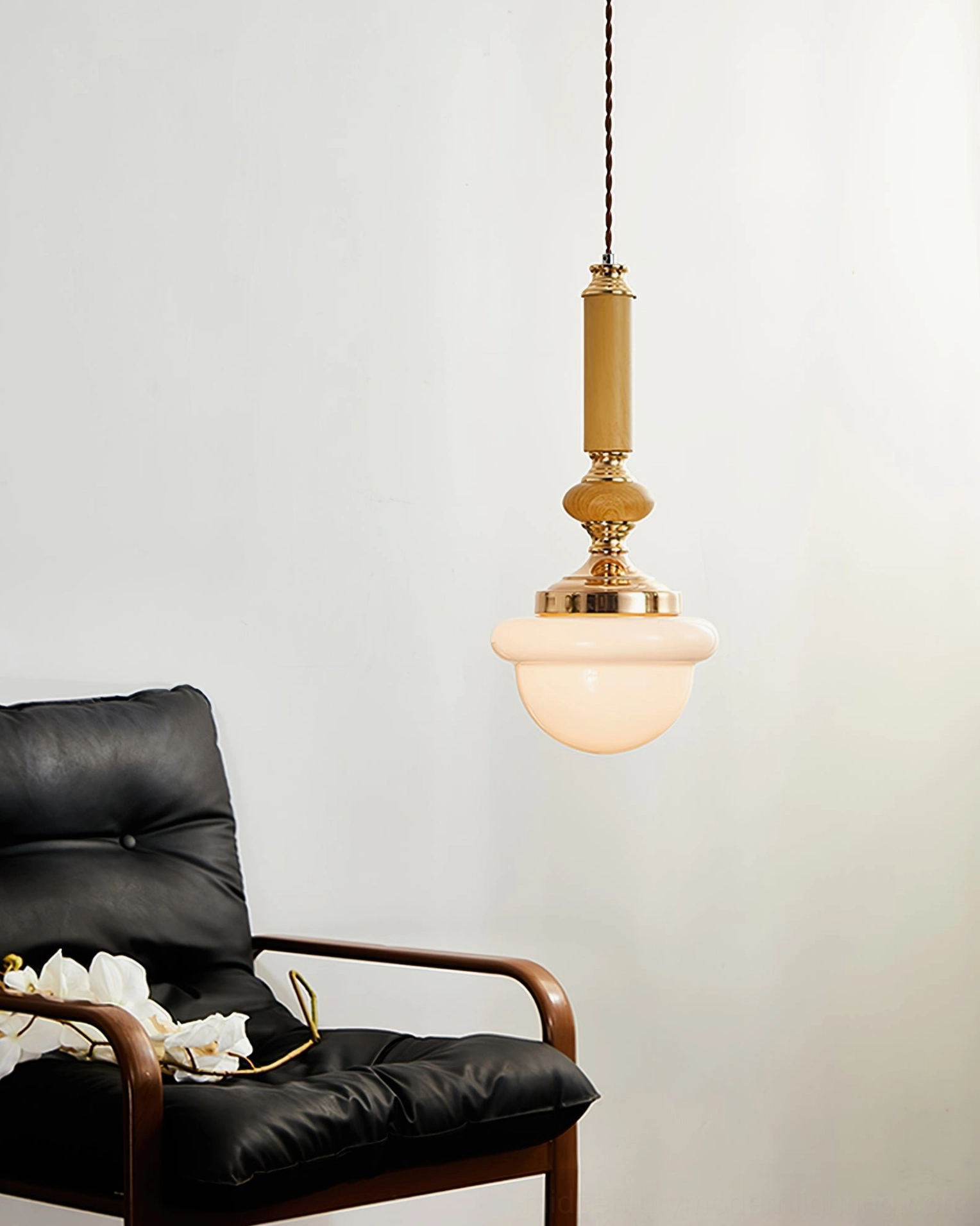 Sorbonne mid-century modern pendant suspended above seating with black leather armchair