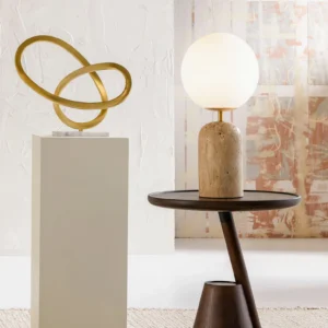 Soren travertine table lamp in modern art exhibition interior with golden abstract wall art and dark wood side table, contemporary styling