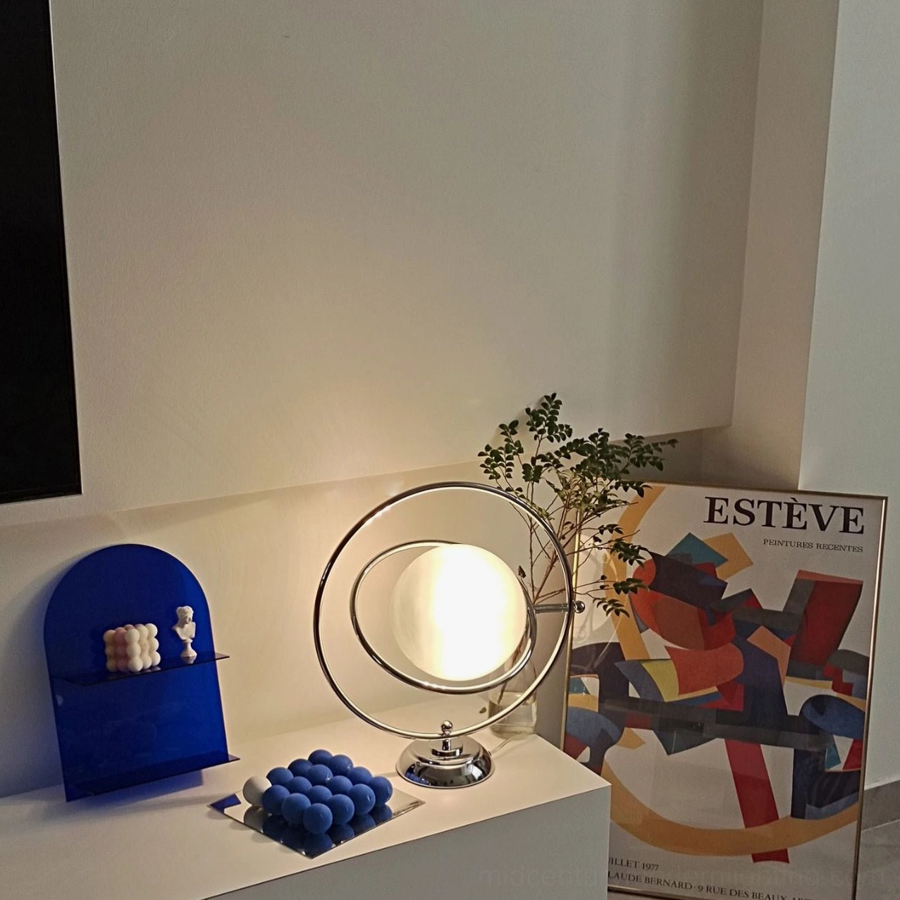Modern space age planet table lamp with silver metallic finish on contemporary surface