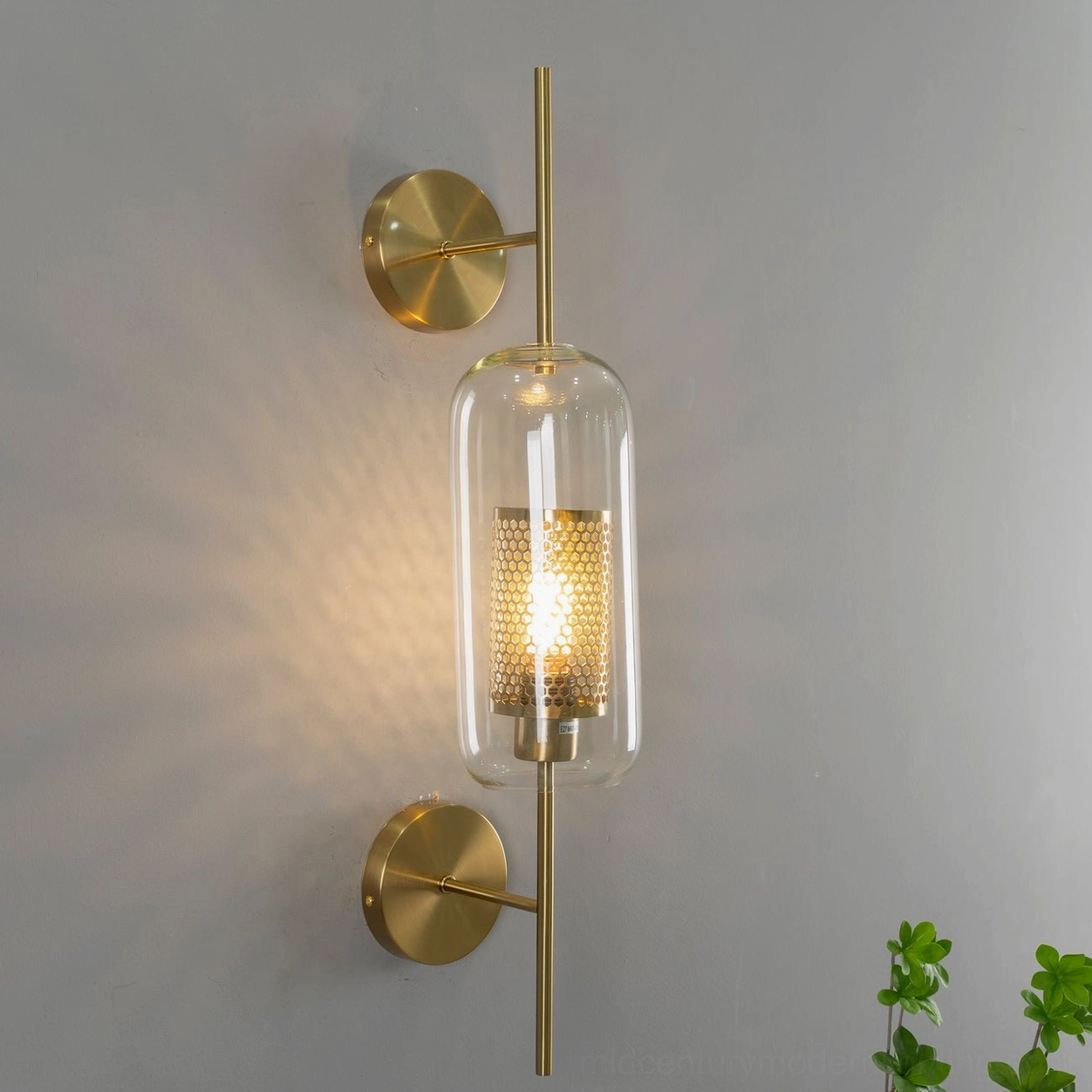 Spherical glass wall sconce with brass frame, eye-level bedroom accent lighting