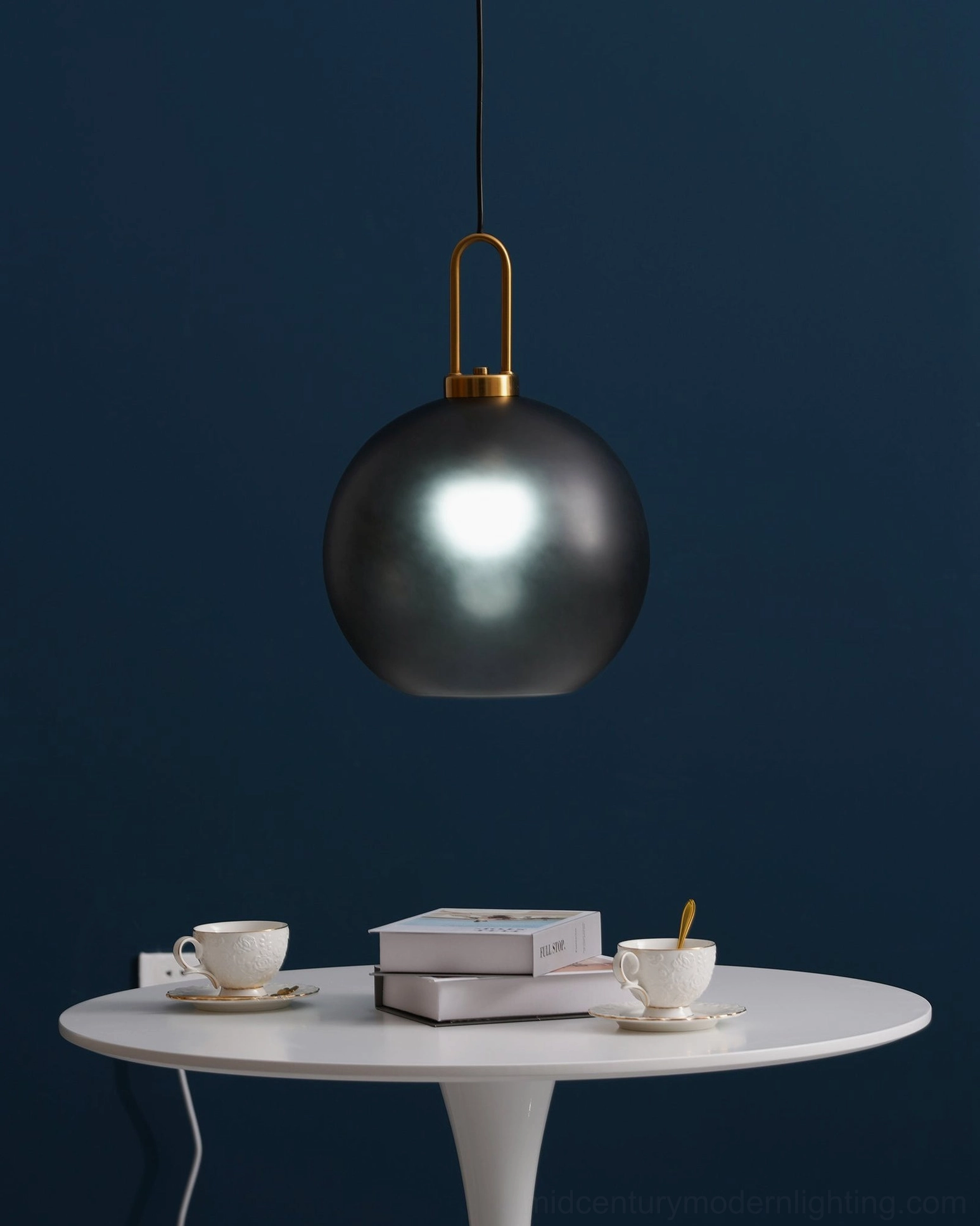 Single matte dark gray spherical smoked glass pendant above white round dining table in modern interior