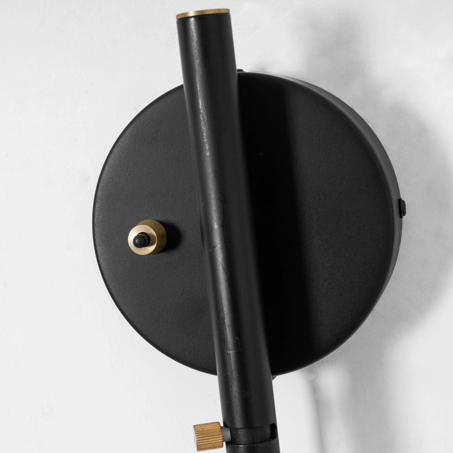 Wall-mounted spider sconce illustrating independent arm rotation at ceiling plate