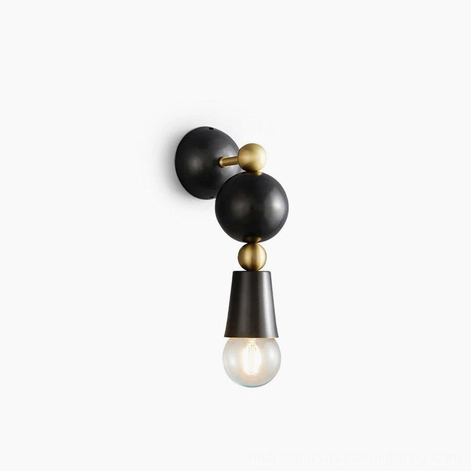 Spindle wall sconce with brass frame and black spherical accents - flat studio view