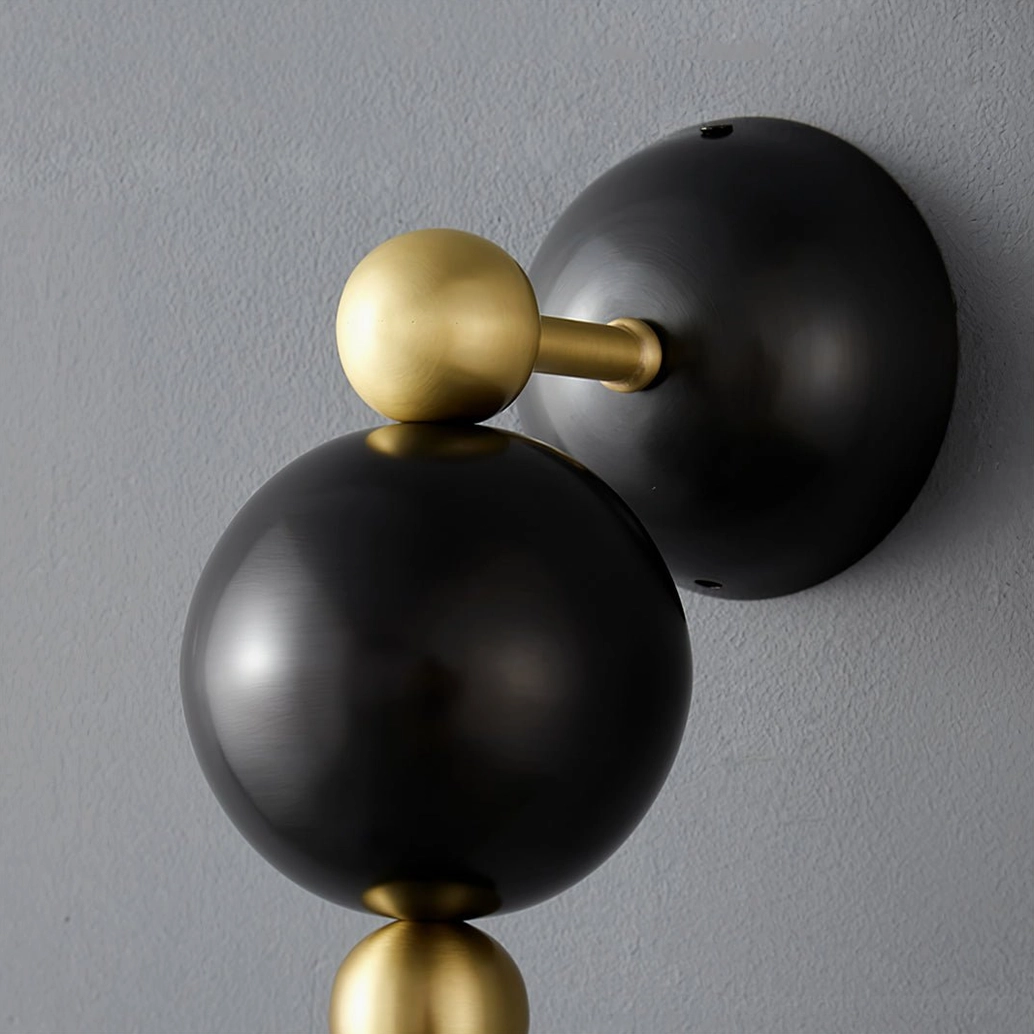 Spindle wall sconce hardware detail showing brass gold connectors and spherical accents