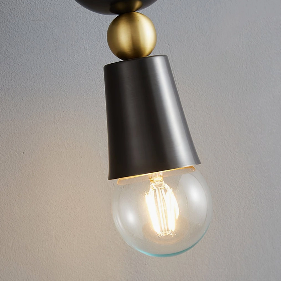 Close-up detail of Spindle wall sconce conical metal shade and brass construction