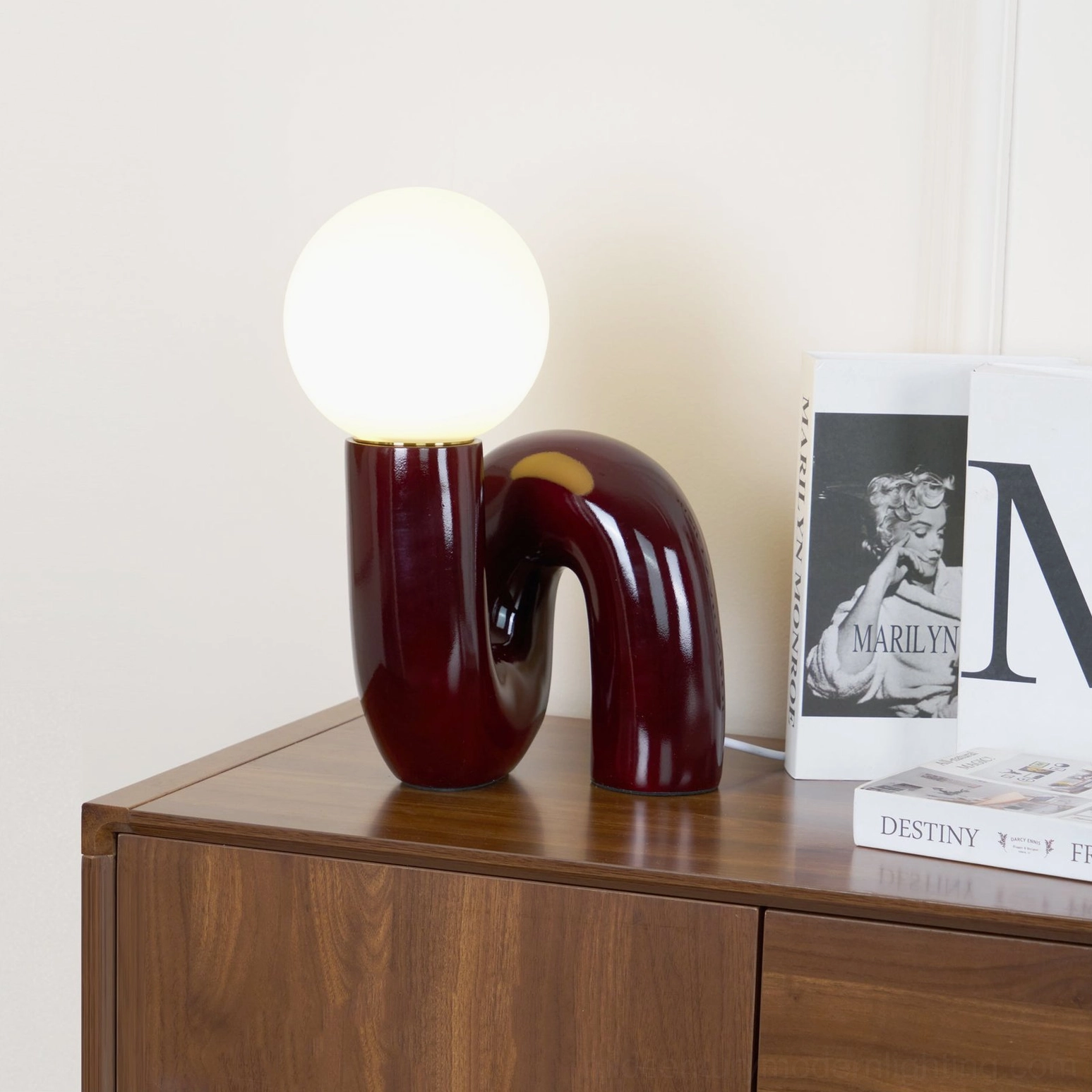Dark Red Spiral Glass Table Lamp displayed on wooden console with vintage Marilyn Monroe coffee table books