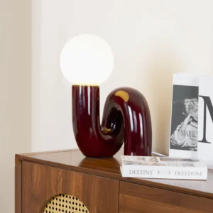 Soft Pink Spiral Table Lamp styled on wooden side table with design books and home decor in modern bedroom setting