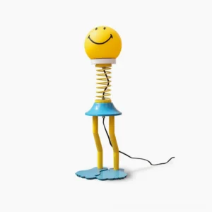 Spiral spring smiley face table lamp front view with black smile print on yellow matte shade, playful mid-century modern design
