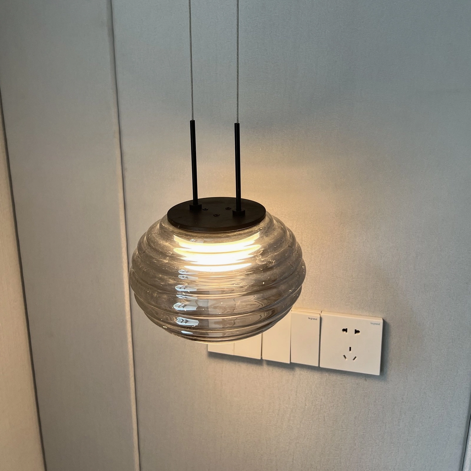 Close-up detail of Splugen ribbed glass texture with clear pattern and black ceiling fixture mounting