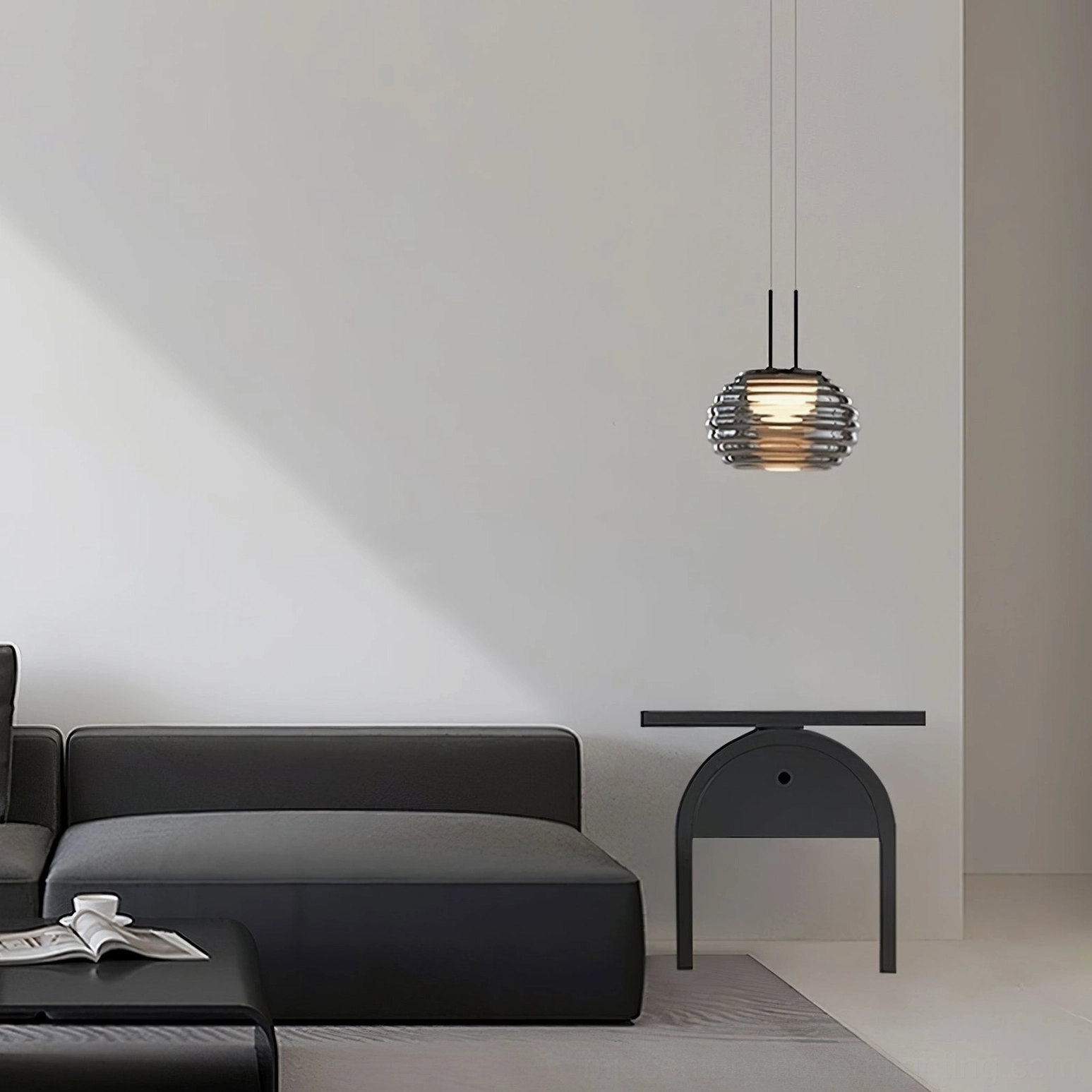 Splugen smoke glass pendant light in modern living room with dark sofa, warm ambient contemporary lighting