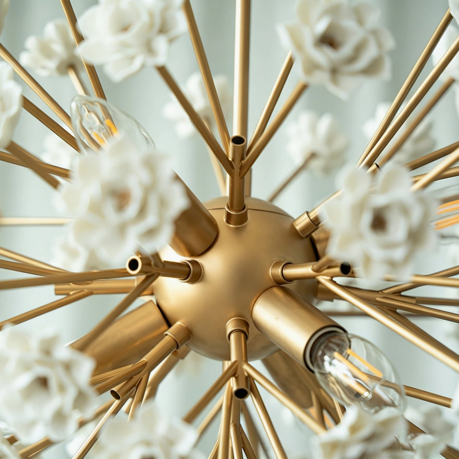 Close-up detail of sputnik chandelier internal structure showing brass hub, metal rods and exposed bulb sockets