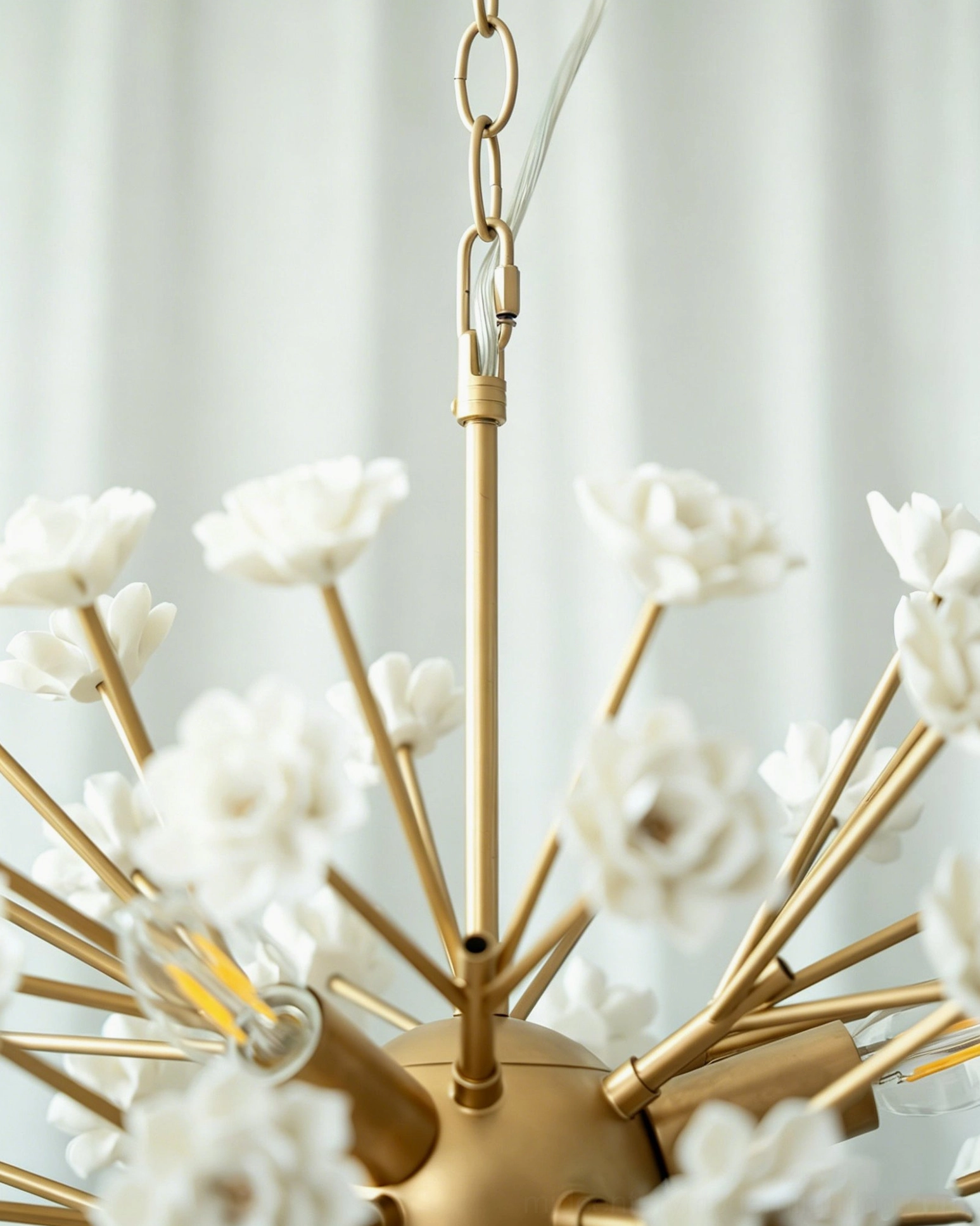 Side view of botanical sputnik chandelier with hanging brass chain and compact spherical design