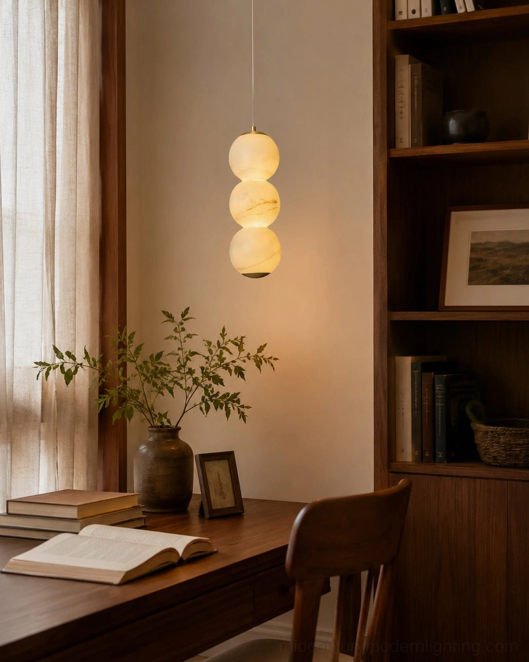 Warm glowing stacked globe pendant above wooden cabinet and dining table modern kitchen