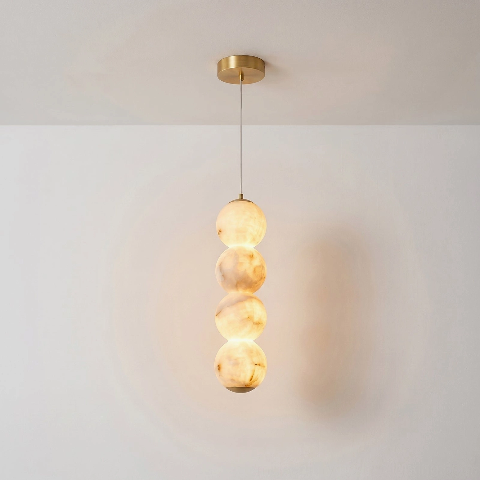 Stacked globe alabaster pendant warm brass hardware natural stone translucent glow