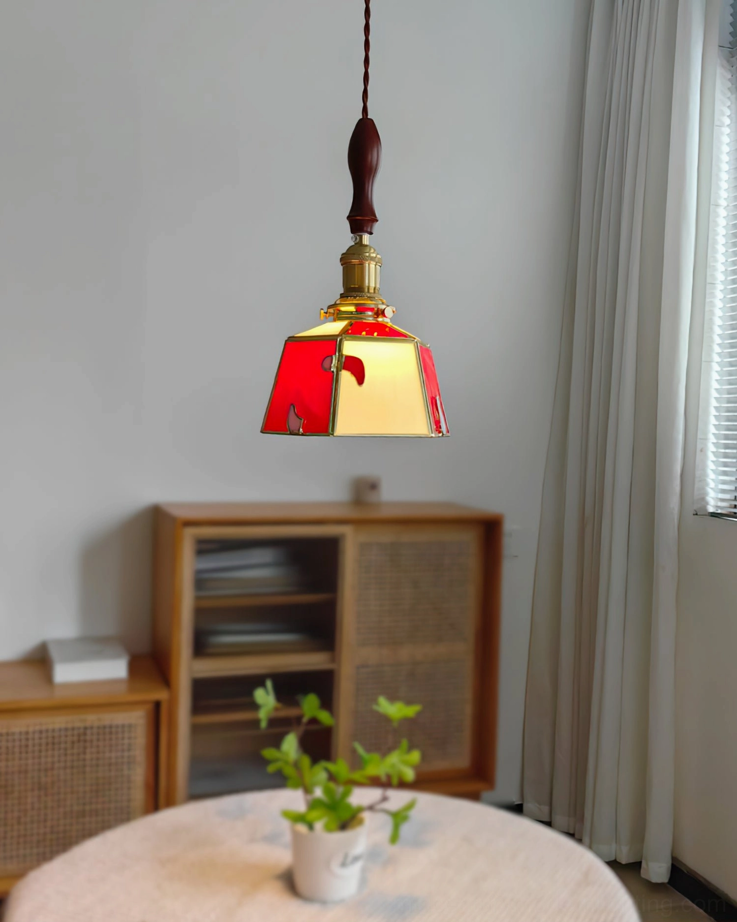 Stained glass pendant lamp casting golden light above wooden cabinet in contemporary living room with window blinds