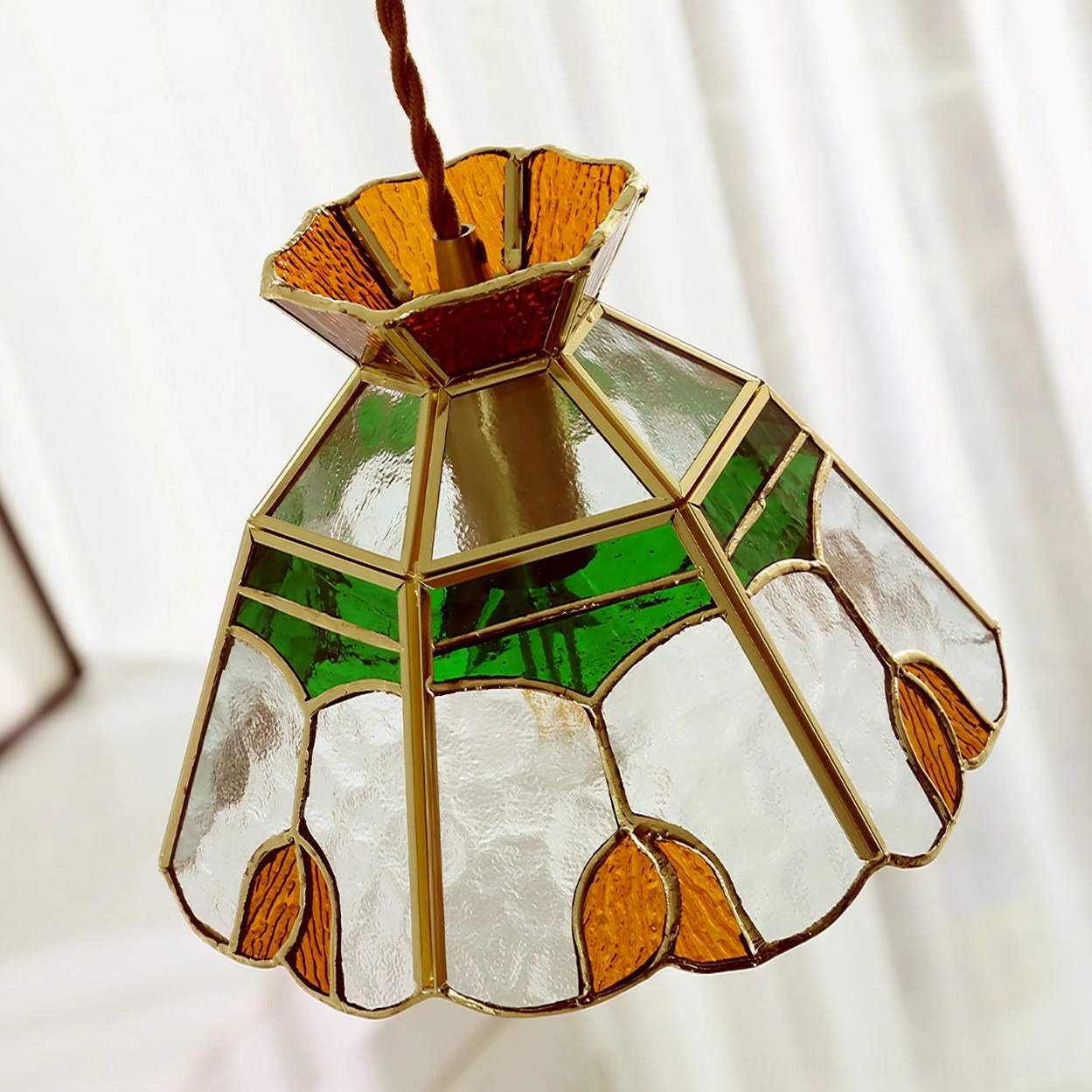 Close-up detail of vitral pendant lamp showing water ripple clear glass texture and brass metal framework