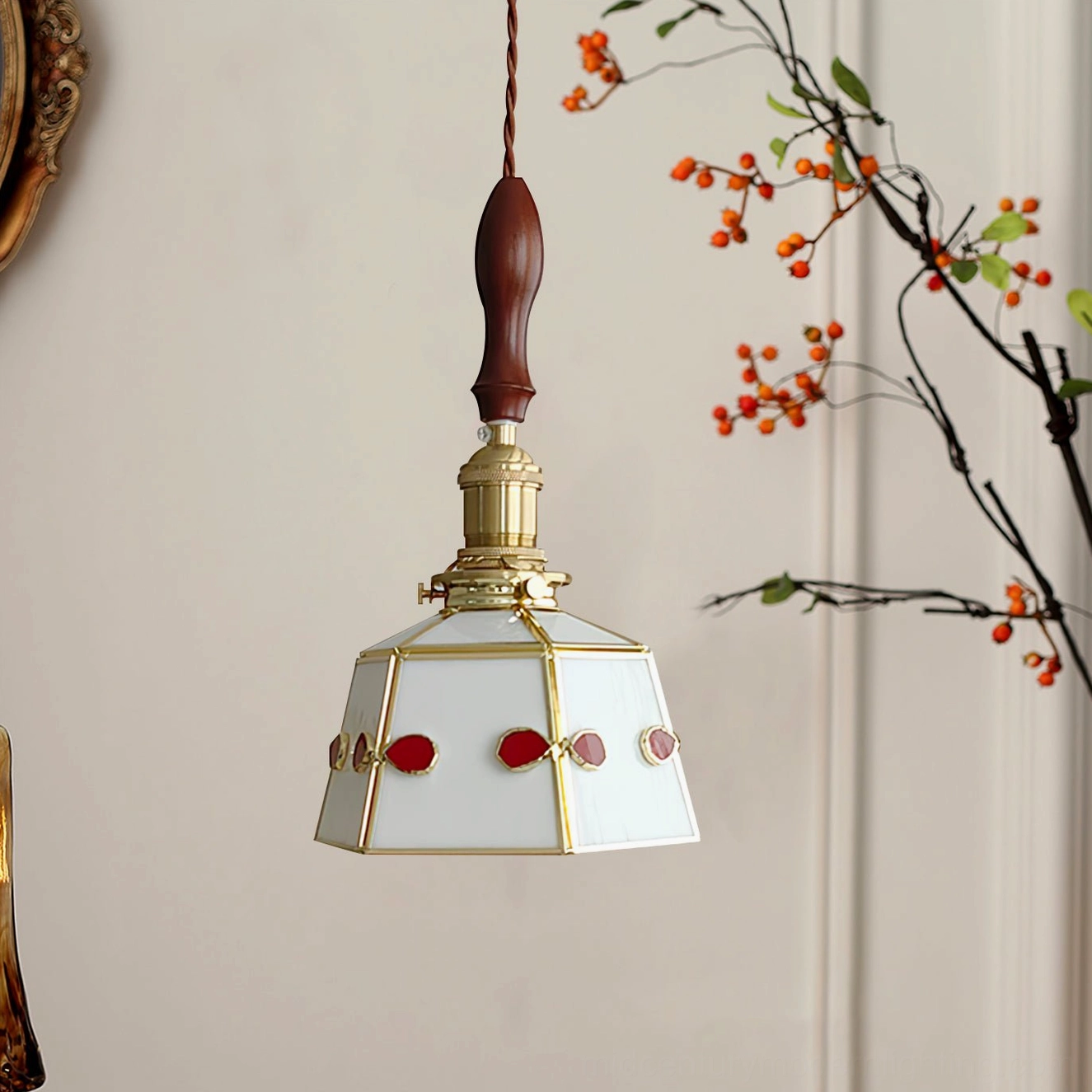 Stained glass pendant lamp hanging indoors with red and white glass jewels and decorative branches—side angle