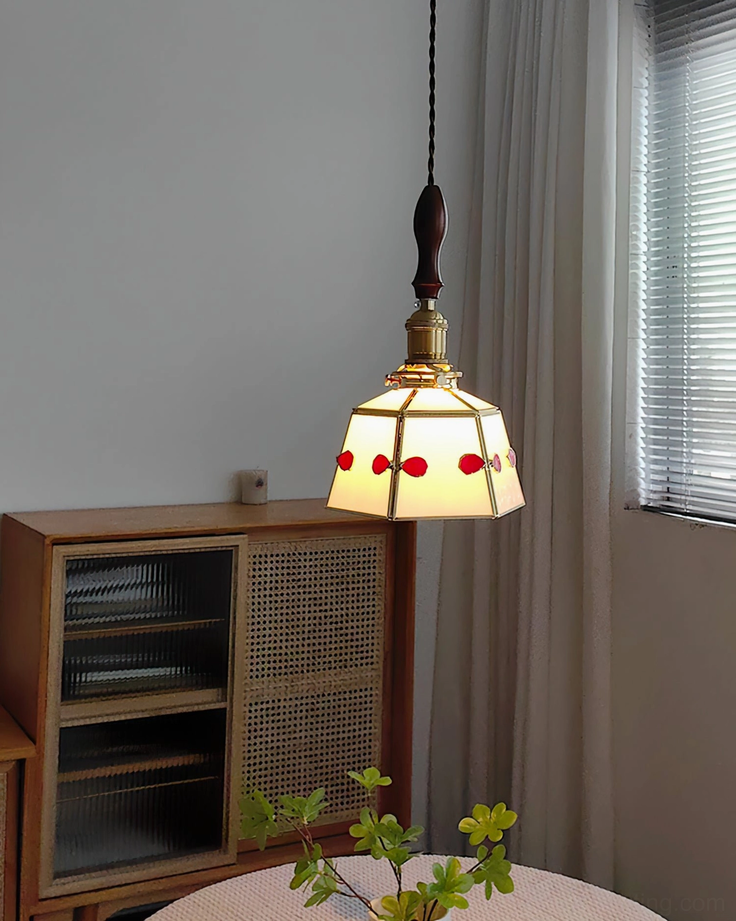 Illuminated stained glass pendant lamp with warm red glass jewels creating ambient glow in residential living space