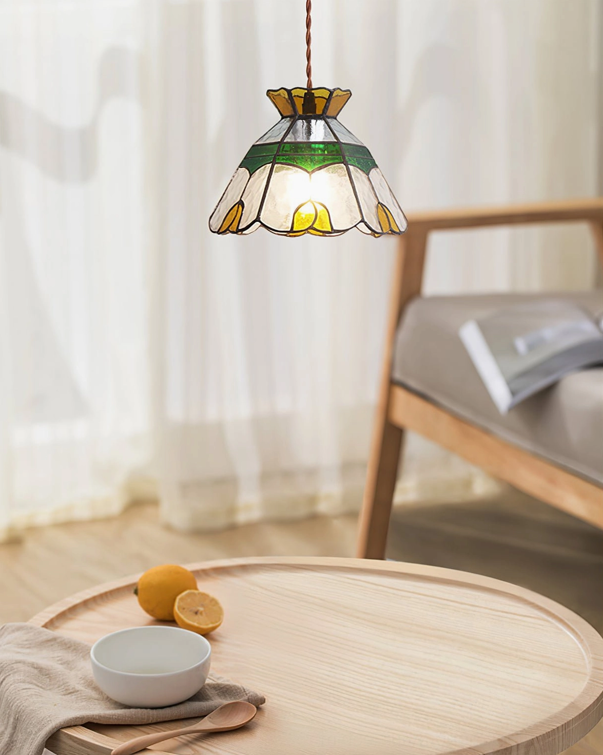 Tiffany-style vitral pendant lamp illuminating wooden side table lounge with fruit bowl and linens