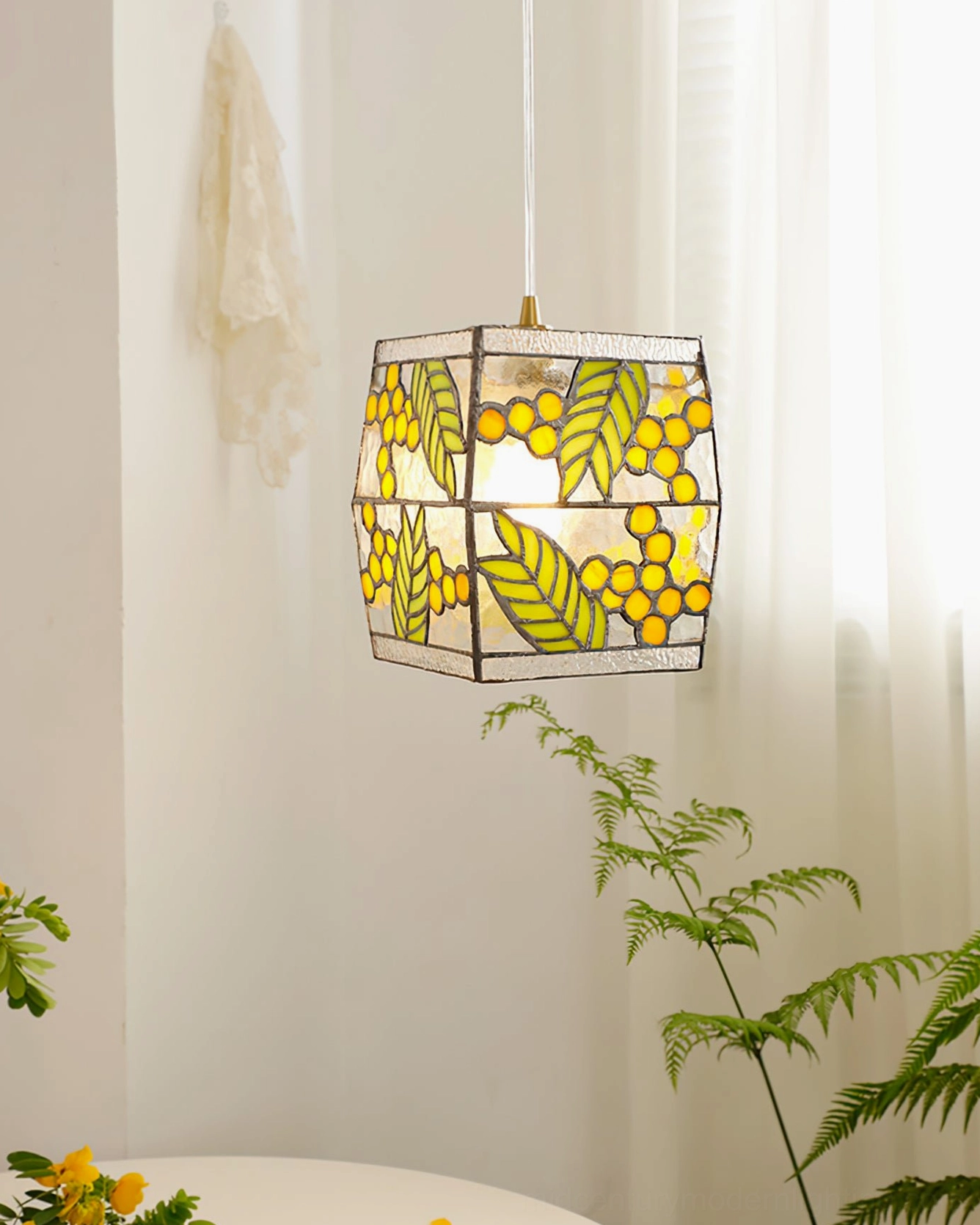 Hanging stained glass seed pendant lamp in bright room with green plants, warm light illuminating leaf and berry pattern